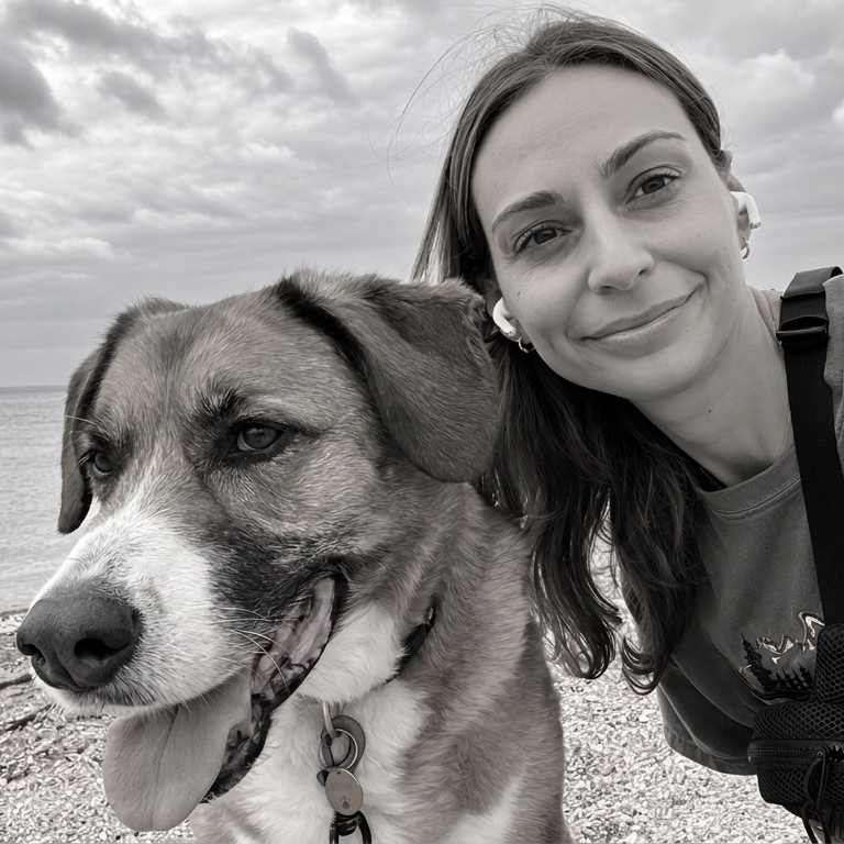 Julia Morrissey with her dog Maya on a beach, black-and-white photograph.