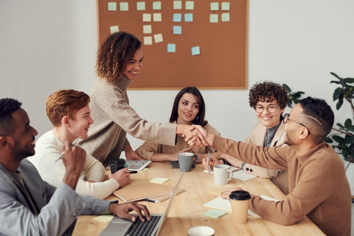 Colleagues shaking hands during a modern office meeting.